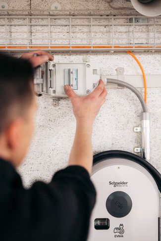 Ein Mitarbeiter der ISP Electro Solutions AG bei der Installation einer Ladestation für Elektroautos.