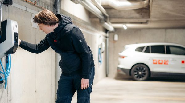 Ein Mitarbeiter der ISP Electro Solutions AG bei der Installation einer Ladestation für Elektroautos in einer Tiefgarage.