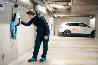 Ein Mitarbeiter der ISP Electro Solutions AG bei der Installation einer Ladestation für Elektroautos in einer Tiefgarage.