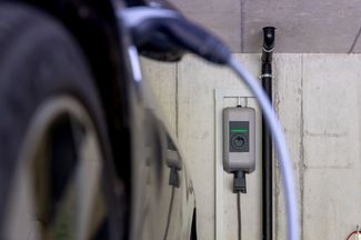 Ein schwarzes Elektroauto lädt an einer Ladestation in einer Tiefgarage.